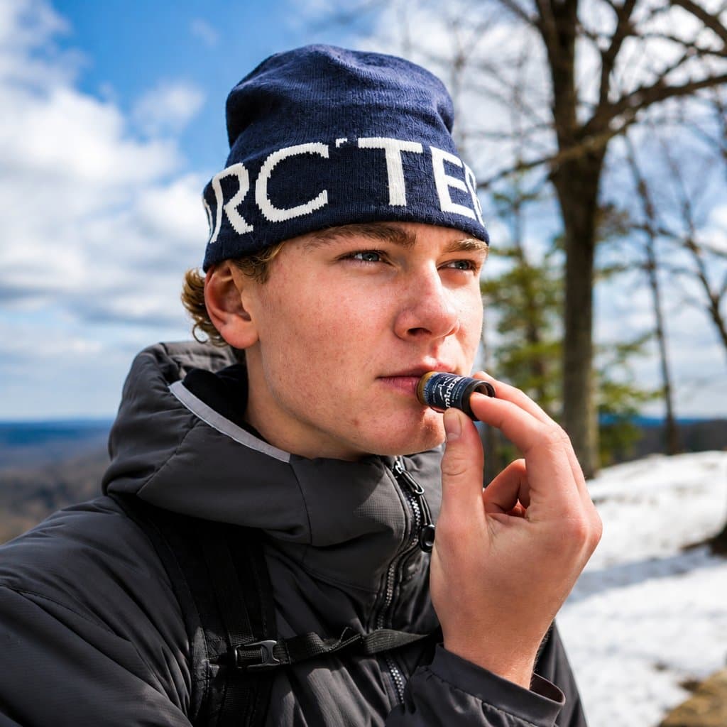 Applying MtnBalm on a snowy overlook