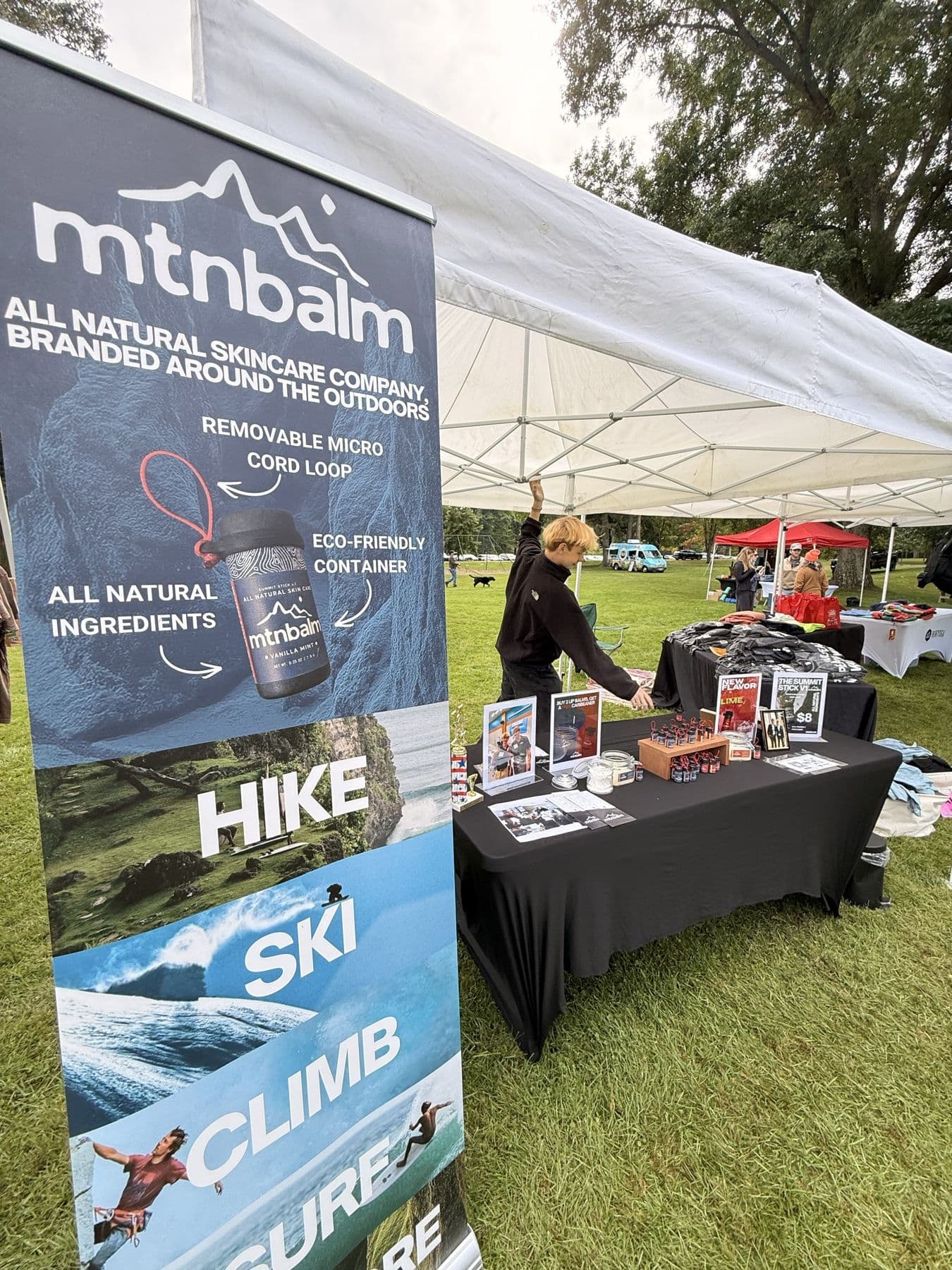 At the MtnBalm booth with our banner